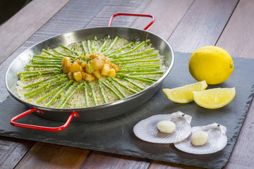 Paella with scollops and asparagus in traditional pan