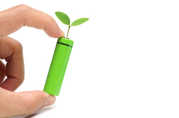 Hand holding a green rechargeable aa battery - using  environmentally friendly product concept