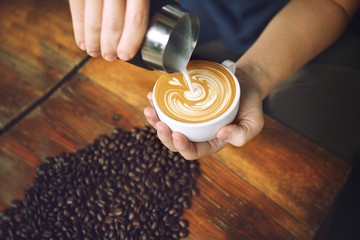 Barista making coffee latte art, focus in milk.