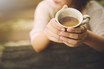 Hands holding hot cup of coffee.