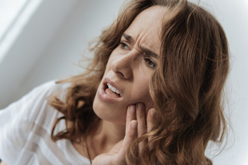 Moody upset woman having a tooth inflammation