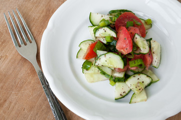 Salad of red tomatoes and cucumbers on a white plate