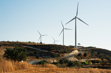 Wind turbine in field. Wind generator. Wind power plant. Electric energy. Road in field. The Nature Of Cyprus. Road through wind turbines