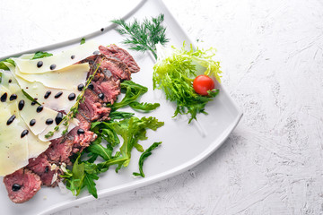 Baked Veal with Parmesan Cheese. On a wooden background. Top view. Free space for your text.