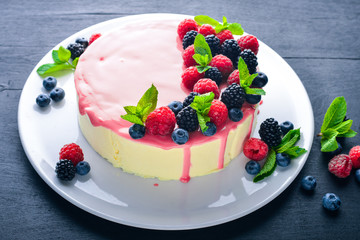 Cake with butter and fresh berries and fruits. Dessert. On a wooden background. Top view. Free space for your text.