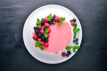 Cake with butter and fresh berries and fruits. Dessert. On a wooden background. Top view. Free space for your text.