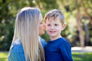 Fototapeta premium Mother and young son embracing and sharing time together outdoors