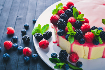 Cake with butter and fresh berries and fruits. Dessert. On a wooden background. Top view. Free space for your text.