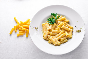 Pasta with cream sauce and parmesan cheese. Italian traditional food. On a wooden background. Top view. Free space for your text.
