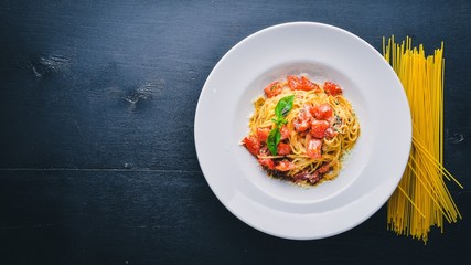 Pasta tomatoes. Italian traditional food. On a wooden background. Top view. Free space for your text.