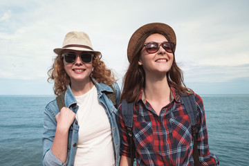 Two girls are traveling along the seashore