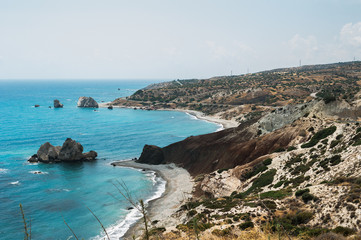 Fototapeta na wymiar The mountains and the sea from a height. Seascape. Beautiful coast of Cyprus. Aphrodite Bay in Cyprus. Aphrodite's rock in Cyprus. The Beach Of Aphrodite