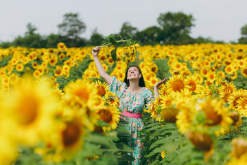 Obraz na płótnie Canvas Brunette girl in a field of sunflowers like in the shower