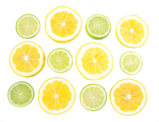 Obraz premium Yellow and green lemon and lime slices on white background