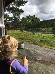 Child watching her father fishing in Norway