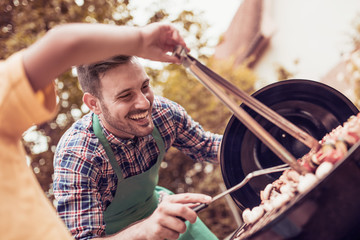 Young man preparing barbecue outdoors