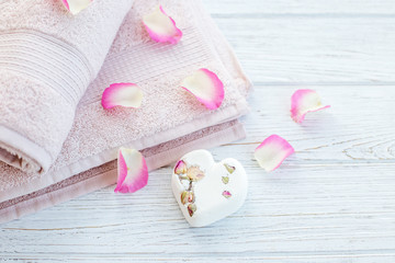 Towels and salt for bath and rose petals. Top view. The concept of spa, relaxation and lifestyle.