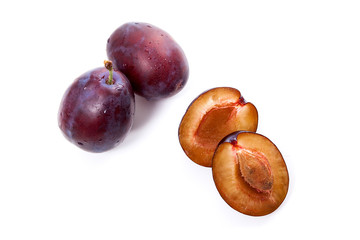 Group of whole and half of ripe plums isolated on a white background..