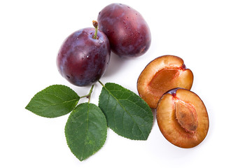 Group of whole and half of ripe plums with leaf isolated on a white background..