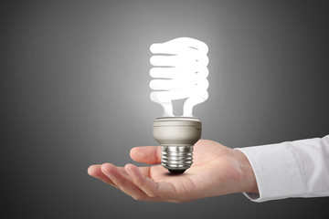 hand holding light bulb with energy