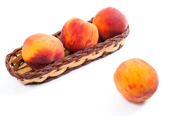 Single ripe peach fruit and several in basket isolated on white background.