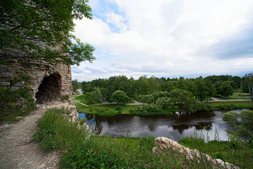 Summer landscape with a river and an ancient limestone tower