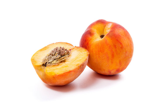 Ripe peach fruit and a half isolated on white background.