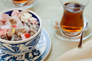 Delicious Turkish delight with tea on a light background. Turkish lukum.