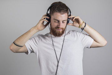 Hombre joven pelirrojo escuchando musica