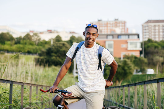 Portrait of smiling young man sitting on bicycle