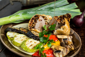 Grilled meat and vegetables on rustic wooden table