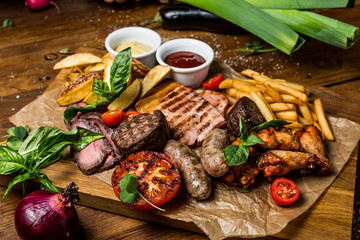 Grilled meat and vegetables on rustic wooden table