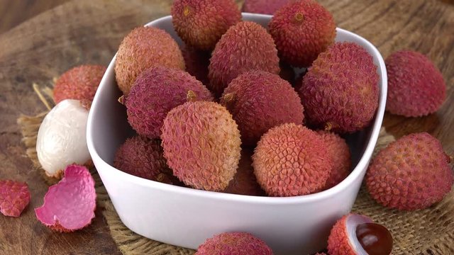 Lychees (rotating on a wooden plate; seamless loopable; 4K)