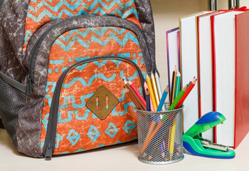 School backpack with school supplies. Books, colour pencils, stapler