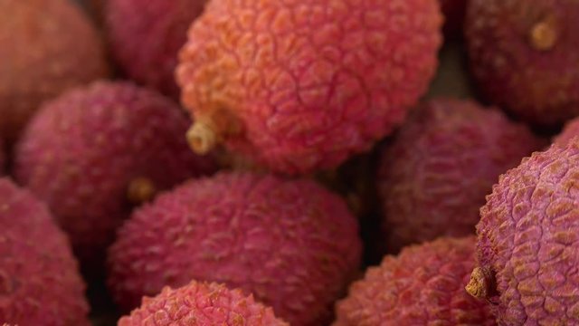 Portion of Lychees rotating on a wooden plate (not loopale; 4K)