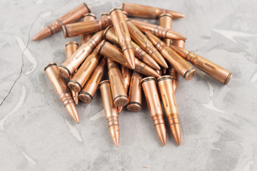 Heap of metal bullet for assault rifle on old grey broken concrete