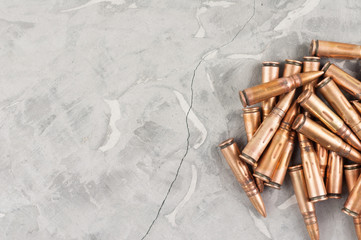 Heap of metal bullet for assault rifle on old grey broken concrete