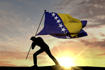 Bosnia flag being pushed into the ground by a male silhouette. 3D Rendering