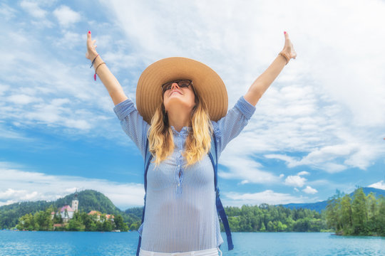 Young woman enjoying outdoors with arms wide open.