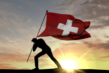 Switzerland flag being pushed into the ground by a male silhouette. 3D Rendering