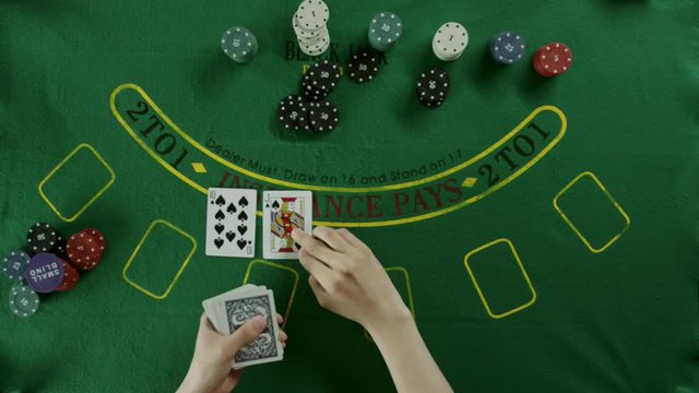 Top view shot. A dealer carefully deals the cards and then takes them in his hands