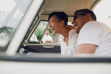 Man and woman hug and smile sitting in an old bus