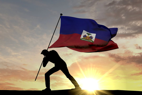 Haiti flag being pushed into the ground by a male silhouette. 3D Rendering
