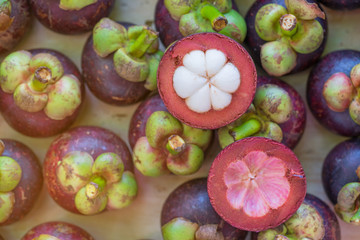Mangosteen and cross section showing the thick purple skin and white,top view