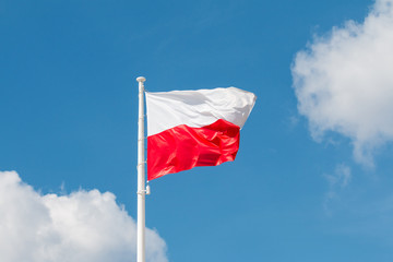Waving national flag of Poland on a flagpole, national colors of Poland.