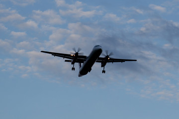 Fototapeta na wymiar The twin-engine plane flying at night close