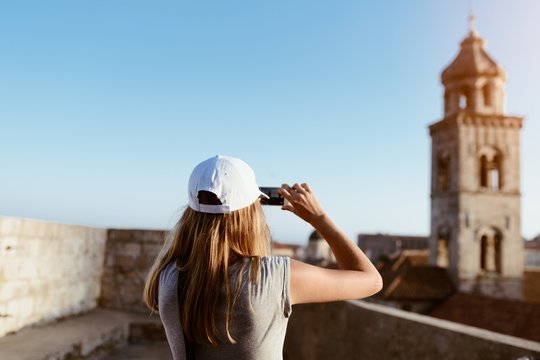 Woman Tourist Taking Photo Of Old Church