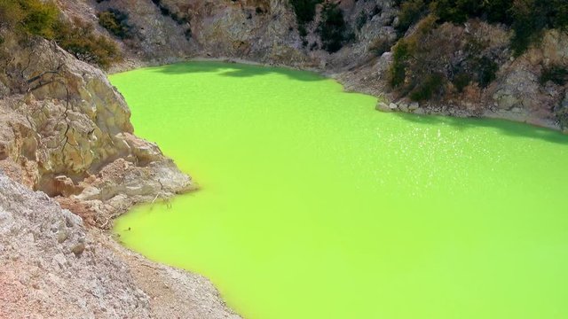 Amazing green colour of geothermal lake Devil's Bath. Wai-O-Tapu Geothermal Wonderland, Rotorua, New Zealand.