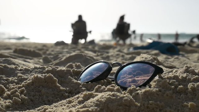 Sunglasses on the sand on the background of the sea.