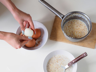 Breakfast with oatmeal and eggs. White table